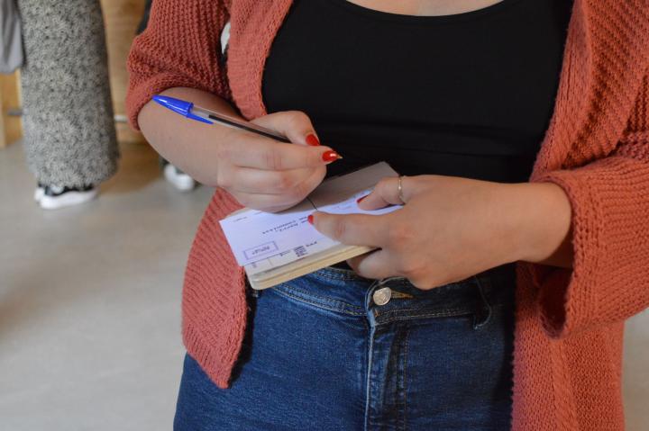 persona escrivint postal a la seva veïna